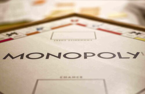 A zoomed-in and sepia-toned image of a Monopoly board, where the word 