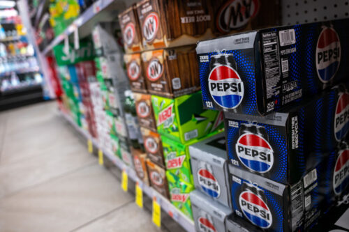 Twelve packs of Pepsi soda are displayed in a store