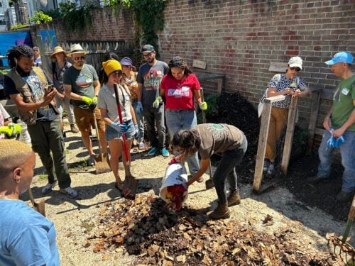 Volunteers dumping and mixing organic materials. Credit: Philadelphia Parks and Recreation