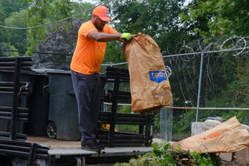 Team member dumping trimmings from collection bag. Credit: Julian Moore-Griffin, Philadelphia Parks and Recreation