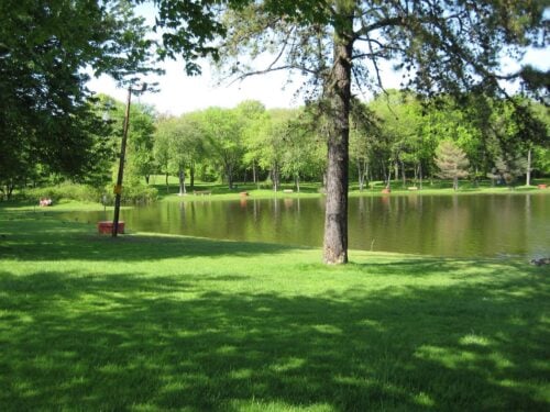 A grassy park next to a pond in East Longmeadow, MA