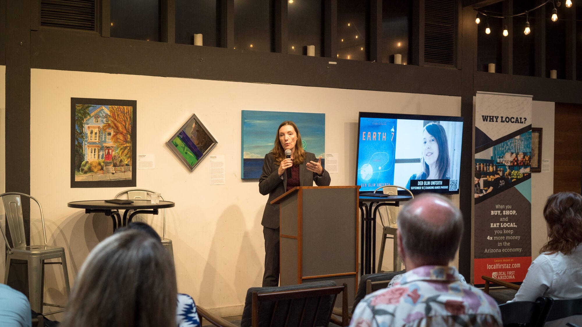 ILSR Co-Director Stacy Mitchell speaks at a podium in front of a seated crowd.